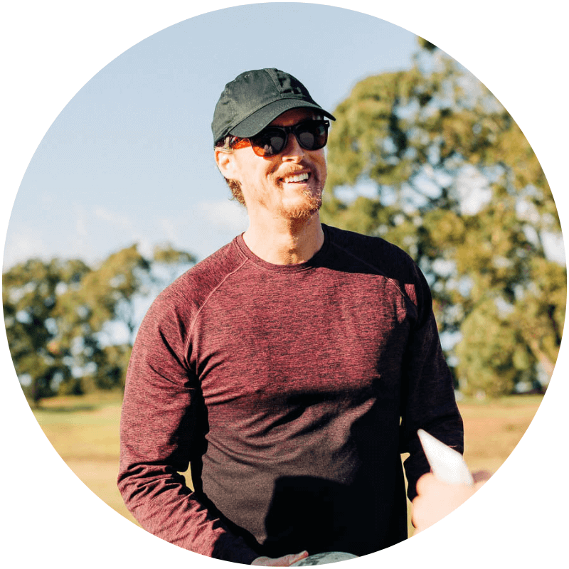 A 40 something year old man smiling while standing on a field wearing sun protection